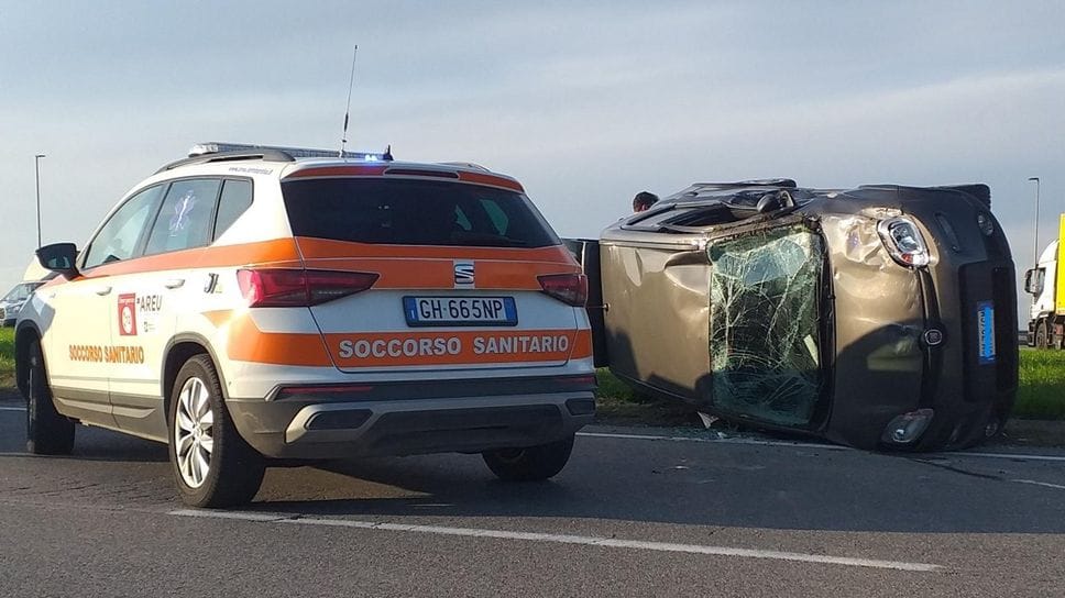 Una delle due auto coinvolte, ribaltata, e l’automedica intervenuta per i soccorsi