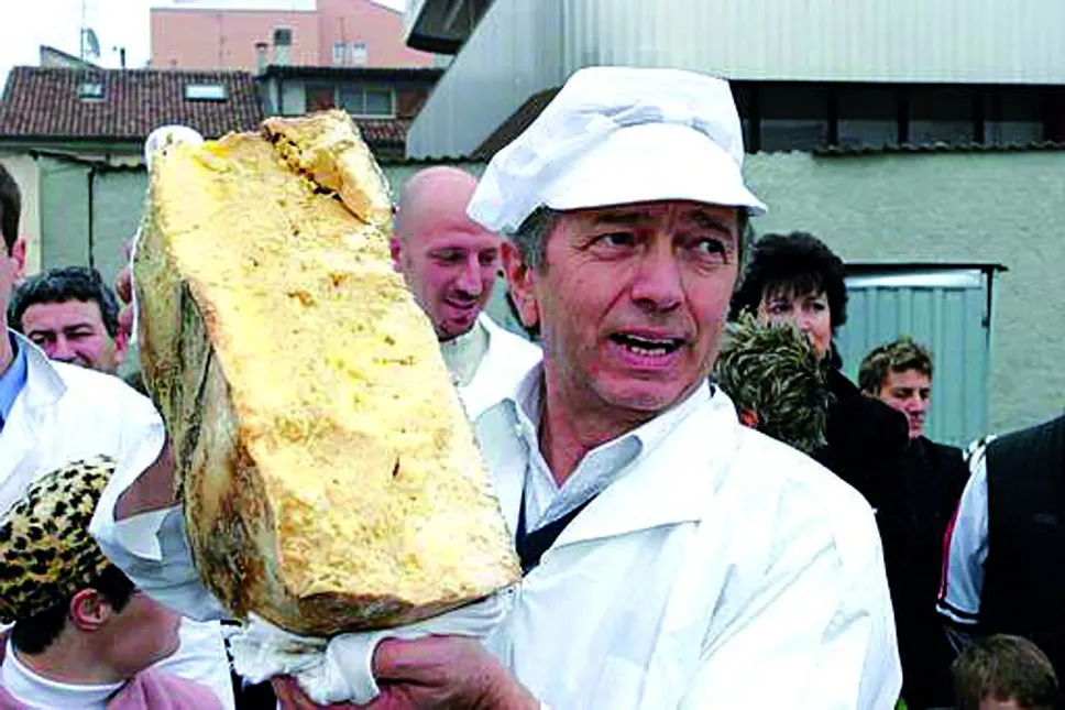 Angelo Frosio mentre disseppellisce una forma di Grana rimasta sotto terra per quattro anni, e la assaggia