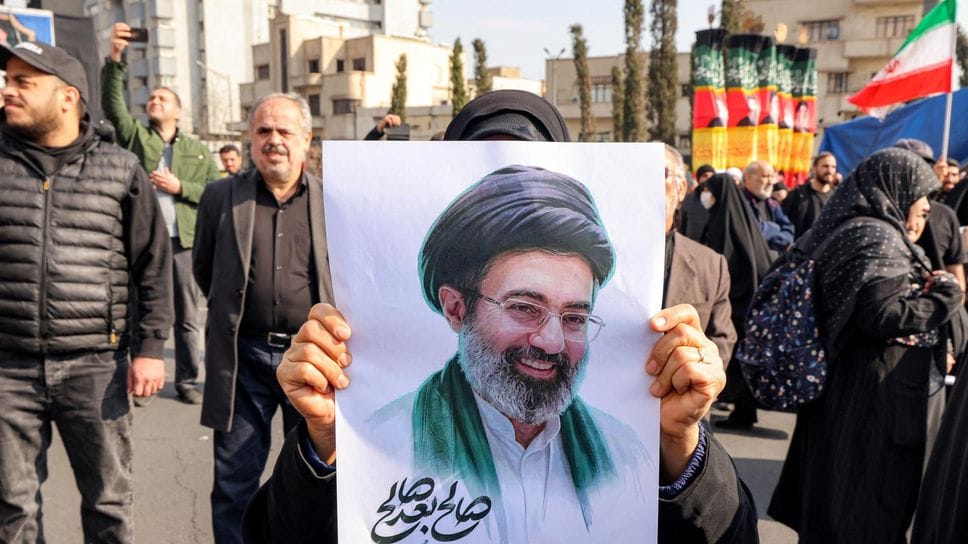 Teheran, 9 marzo 2026: una donna mostra una foto della Guida Suprema dell’Iran, Ayatollah Mojtaba Khamenei (AFP/SIR)