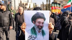 Teheran, 9 marzo 2026: una donna mostra una foto della Guida Suprema dell’Iran, Ayatollah Mojtaba Khamenei (AFP/SIR)